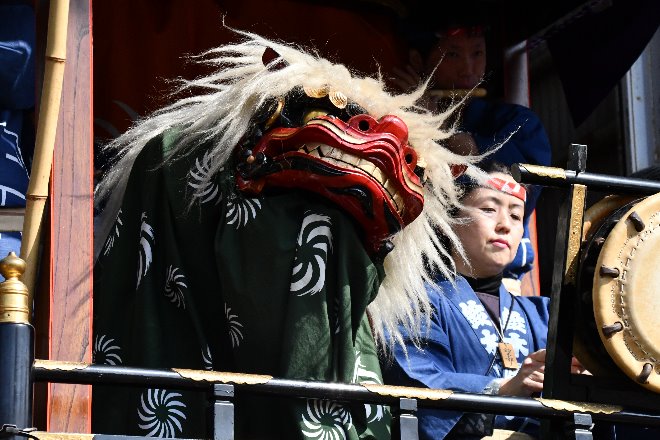 山車の上で踊る獅子舞の写真