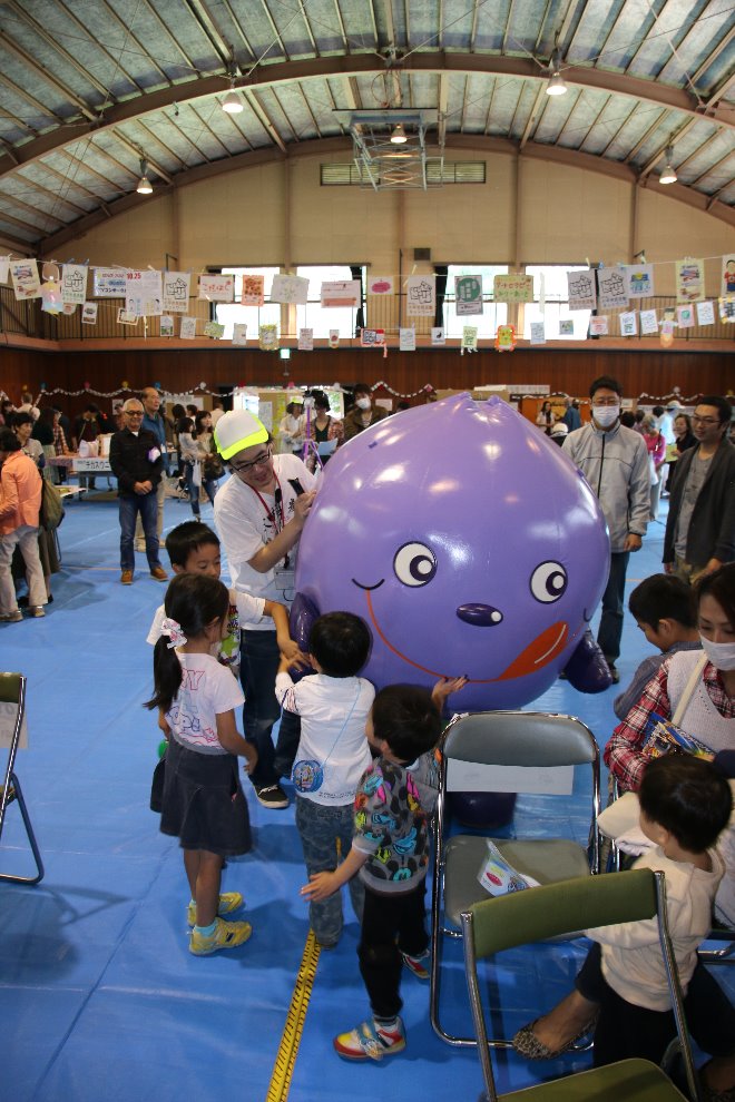 体育館でぶるべーが子どもたちに囲まれている写真